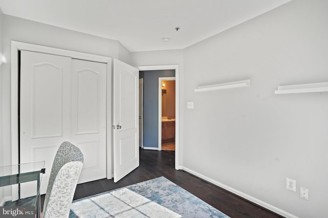 bedroom with dark hardwood / wood-style floors and a closet