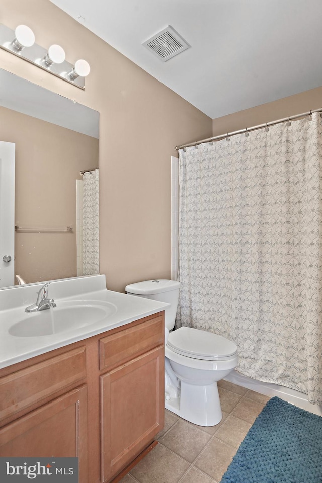 bathroom featuring vanity, tile patterned floors, and toilet