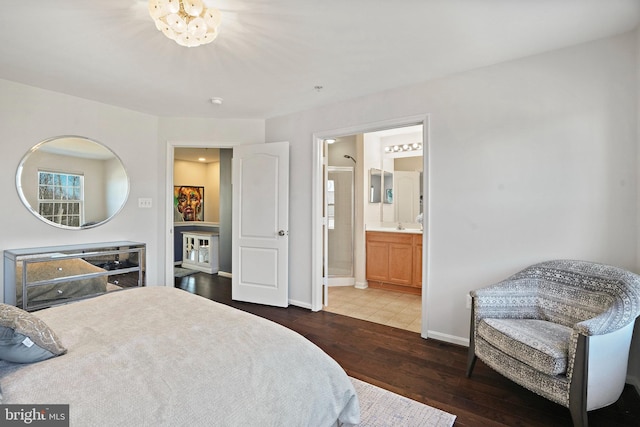 bedroom featuring connected bathroom, a notable chandelier, and dark hardwood / wood-style flooring