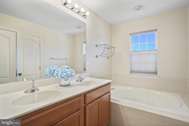 bathroom with vanity and tiled bath