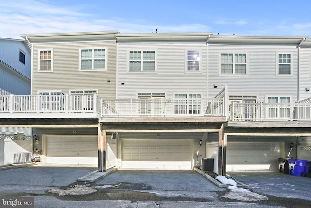 rear view of property with a garage and central AC unit