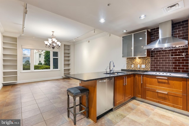 kitchen featuring sink, appliances with stainless steel finishes, dark stone countertops, a kitchen breakfast bar, and wall chimney exhaust hood