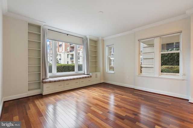 unfurnished room with wood-type flooring, ornamental molding, and built in features