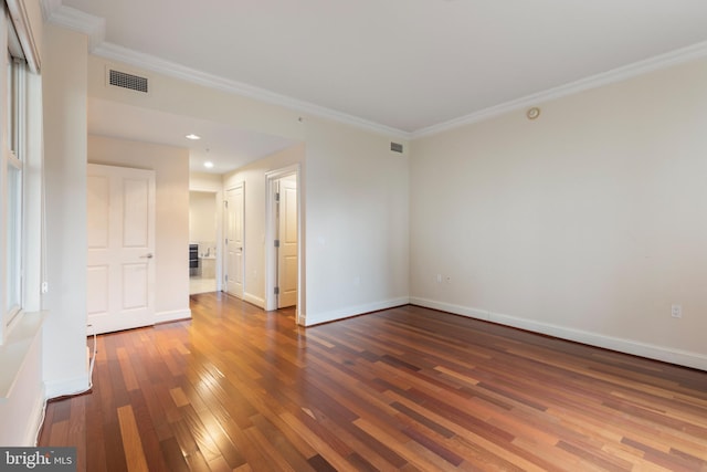 empty room with ornamental molding and dark hardwood / wood-style floors