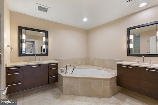 bathroom with vanity, tiled tub, and tile patterned flooring