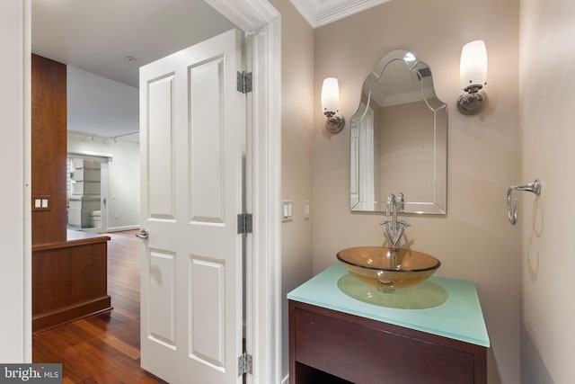 bathroom featuring vanity, ornamental molding, and hardwood / wood-style floors