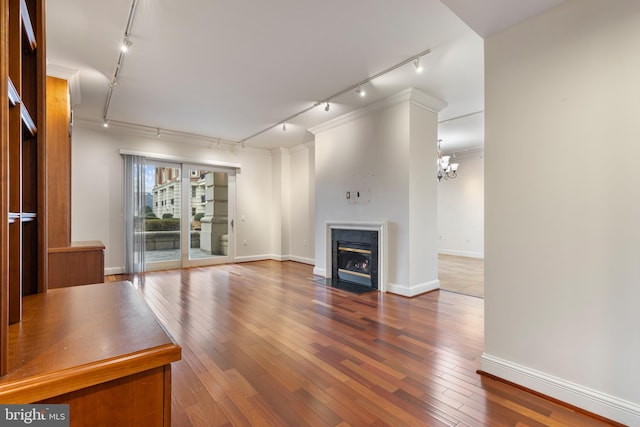 unfurnished living room featuring hardwood / wood-style floors and rail lighting