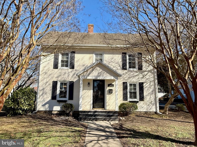 colonial-style house featuring a chimney