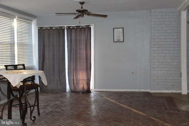 dining room with brick floor, ceiling fan, and baseboards