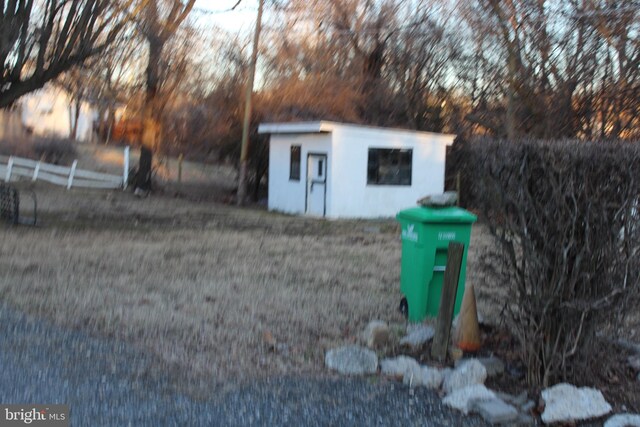 view of outbuilding featuring fence