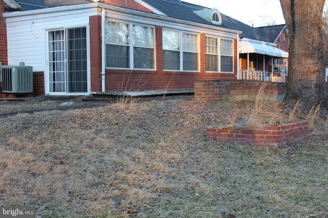 view of side of home featuring cooling unit and brick siding