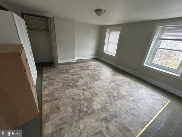 unfurnished bedroom with a closet and baseboards