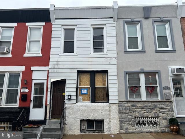 view of property with cooling unit and a wall mounted AC