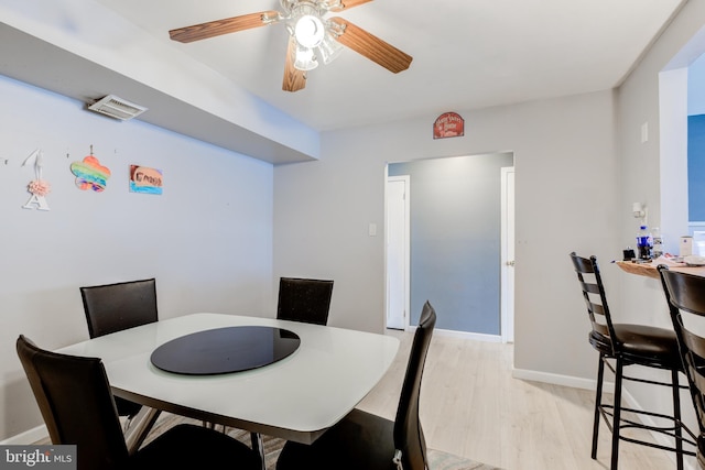 dining space with light hardwood / wood-style floors and ceiling fan