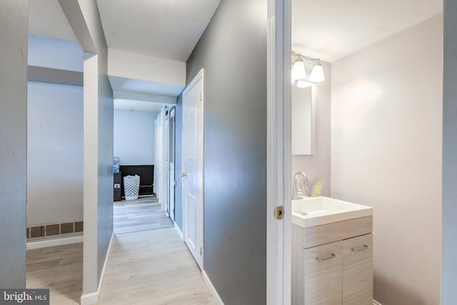 hallway featuring sink and light wood-type flooring