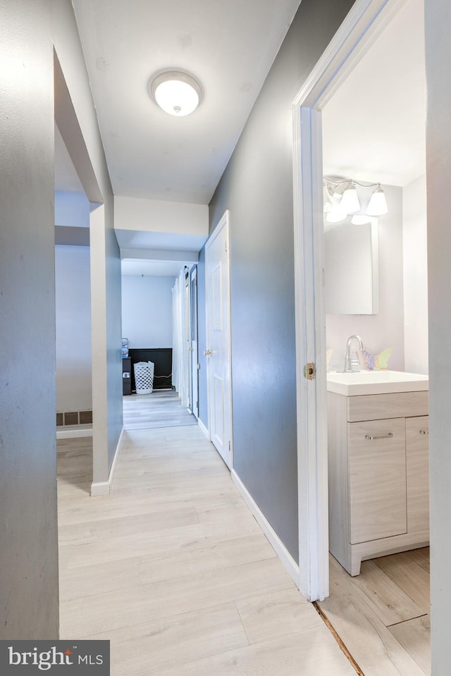 hall featuring sink and light wood-type flooring