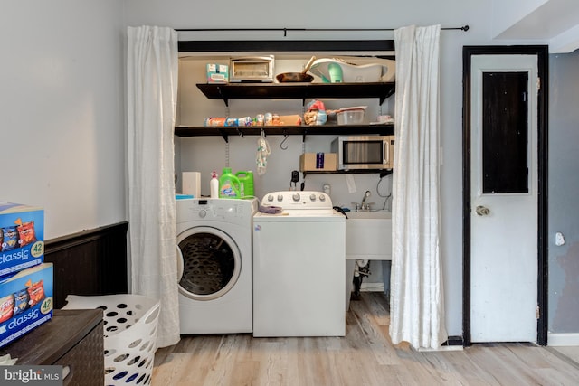 washroom featuring washing machine and dryer and light hardwood / wood-style floors