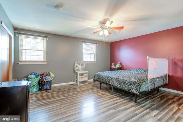 bedroom with wood-type flooring, ceiling fan, and a closet