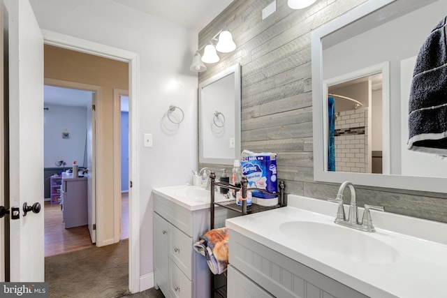 bathroom featuring vanity, wooden walls, and curtained shower