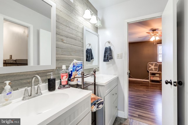 bathroom with vanity, wood-type flooring, wooden walls, and ceiling fan