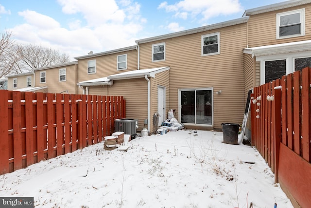 snow covered rear of property with central AC