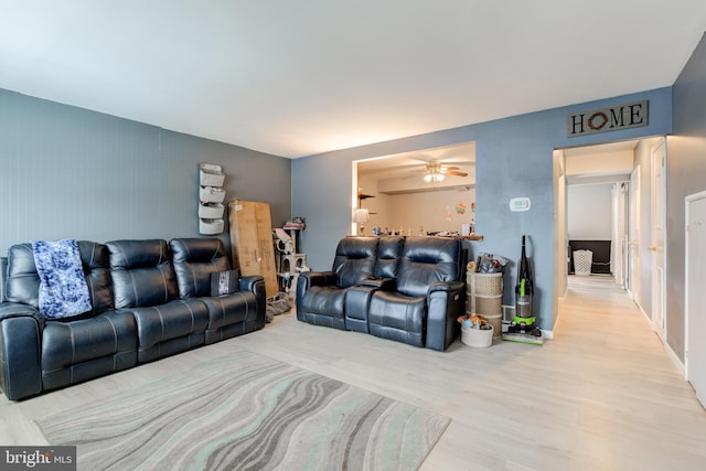 living room featuring ceiling fan and light hardwood / wood-style flooring