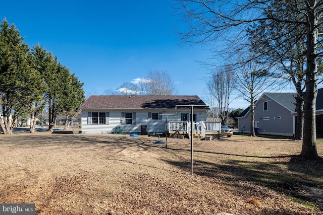 back of property featuring a yard and a wooden deck