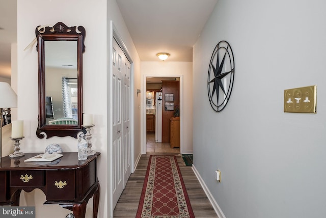 hallway featuring wood finished floors and baseboards