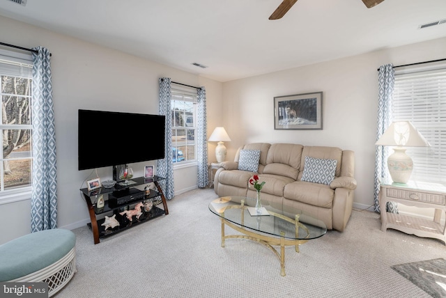 carpeted living room with ceiling fan, visible vents, and baseboards