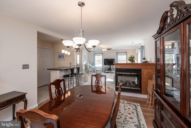 dining space featuring a chandelier, wood finished floors, and a multi sided fireplace