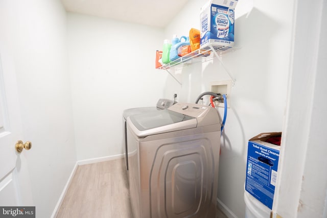 laundry room featuring washer and clothes dryer and light hardwood / wood-style floors