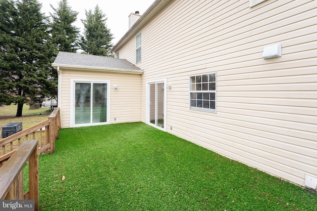 rear view of house featuring a yard and central air condition unit