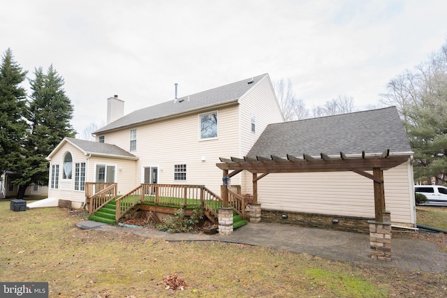 rear view of house featuring a pergola, a deck, a patio, and a lawn