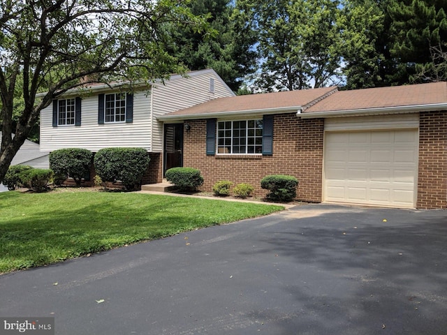 tri-level home with a garage and a front lawn