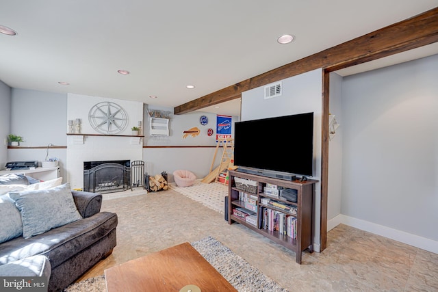 living room featuring beamed ceiling and a fireplace