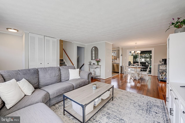 living room featuring ornamental molding, hardwood / wood-style flooring, and an inviting chandelier