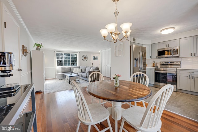 dining room featuring ornamental molding, a chandelier, and light hardwood / wood-style floors