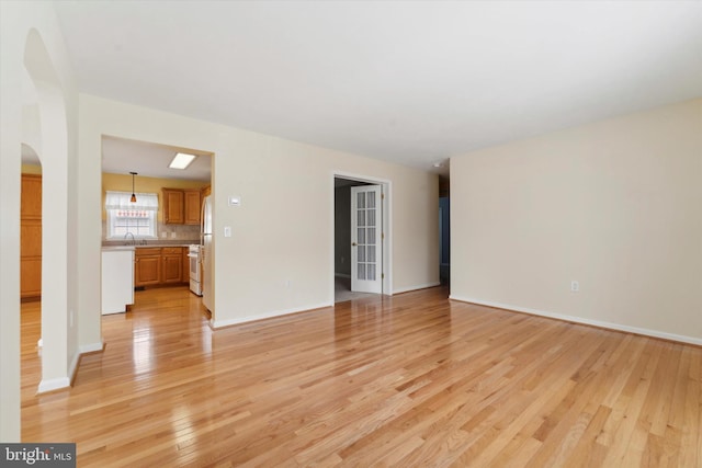 spare room featuring sink and light wood-type flooring