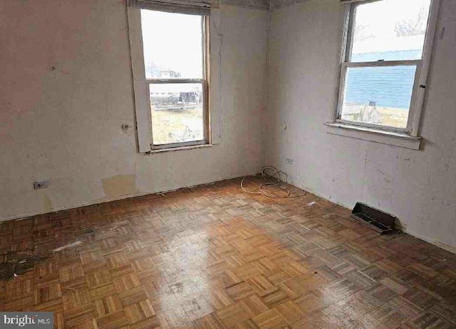 empty room featuring parquet floors and plenty of natural light