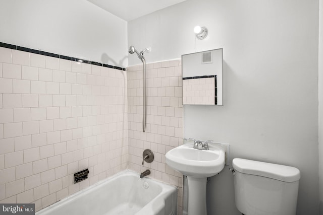 bathroom featuring toilet, visible vents, and shower / bathtub combination