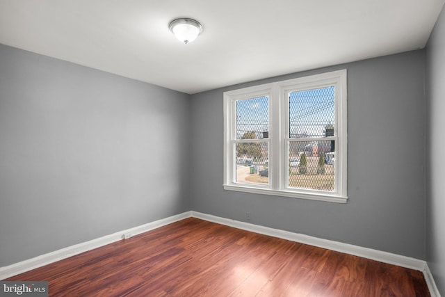 unfurnished room featuring dark wood finished floors and baseboards