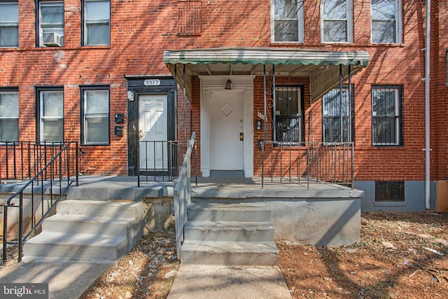 property entrance with cooling unit and brick siding