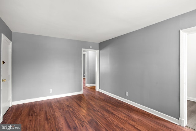 empty room featuring wood finished floors and baseboards