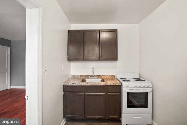 kitchen with white electric stove, dark brown cabinetry, a sink, baseboards, and light countertops