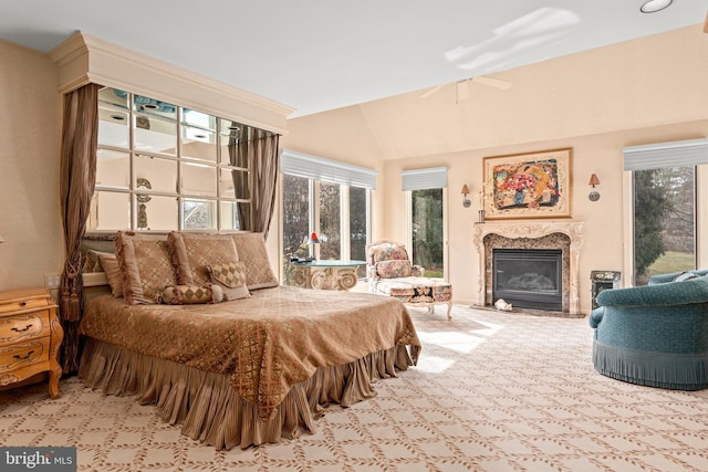 bedroom with light carpet, a premium fireplace, and vaulted ceiling