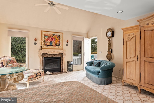 living area featuring lofted ceiling, a premium fireplace, a ceiling fan, and baseboards