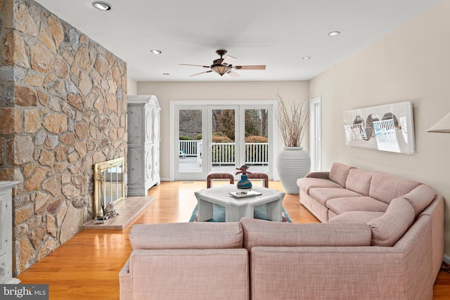 living room with light wood-type flooring, a fireplace, a ceiling fan, and recessed lighting