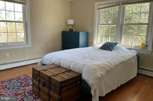 bedroom featuring hardwood / wood-style flooring and baseboard heating