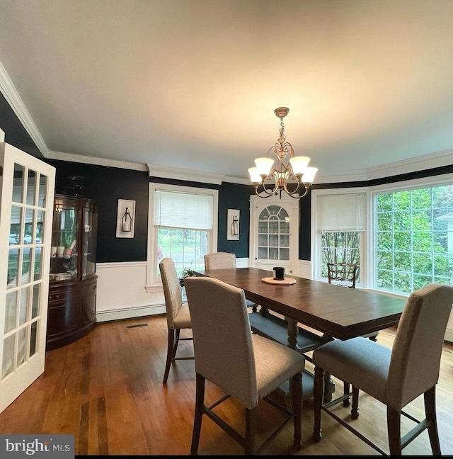 dining room featuring ornamental molding, hardwood / wood-style floors, a chandelier, and a baseboard radiator