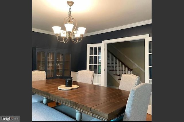 dining area with an inviting chandelier and ornamental molding